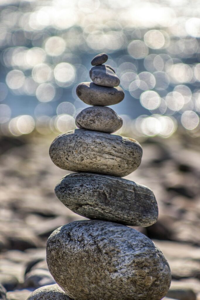 A carefully placed tower of smooth rocks in a natural background, evoking feelings of peace, tranquility, and wellness