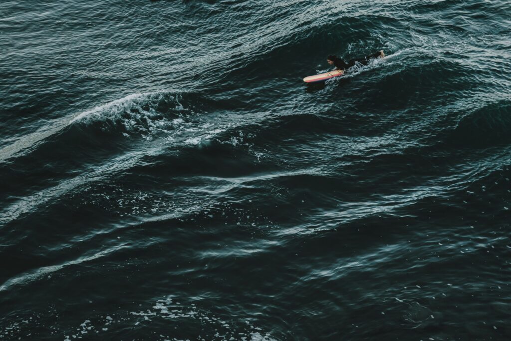 Kayak navigating choppy waters in the middle of a restless sea under a cloudy sky, depicting nervous system challenges